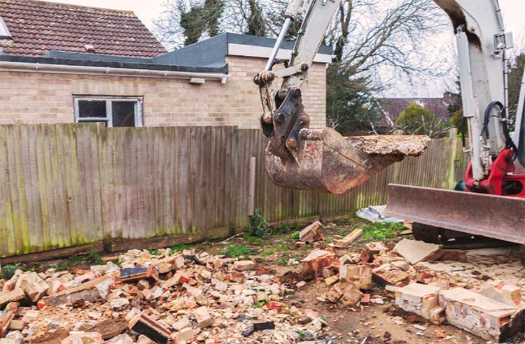 Garage demolition rubble and excavator